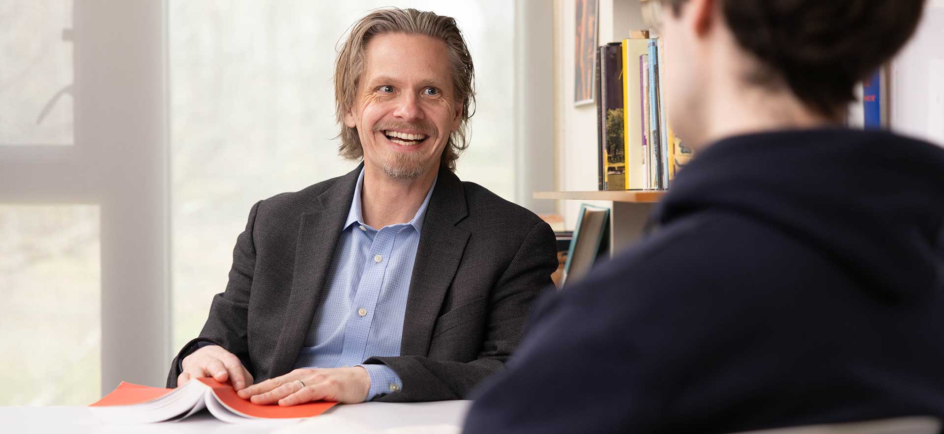 Professor Joel Christensen talks with a student
