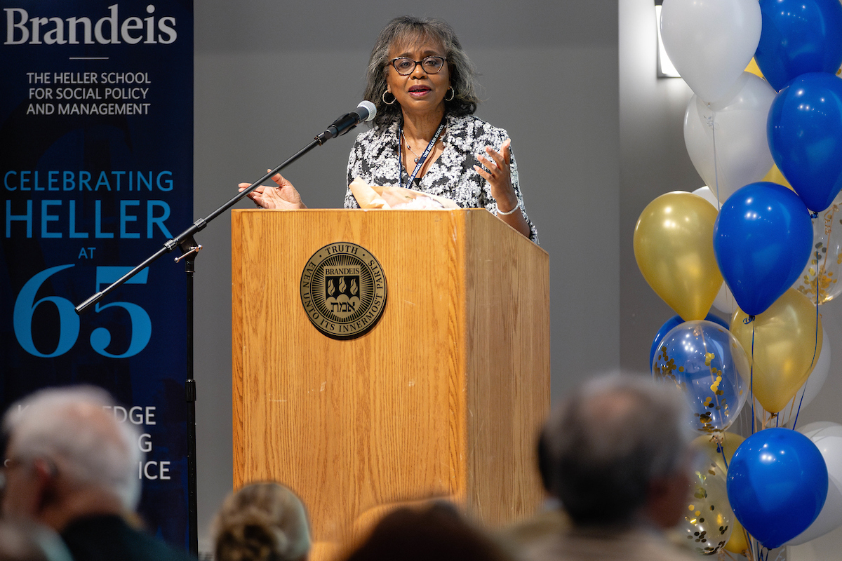 Anita Hill speaking at a wooden podium
