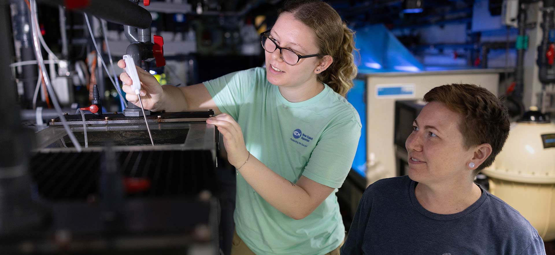 Lyra and her mentor work together next to a fish tank