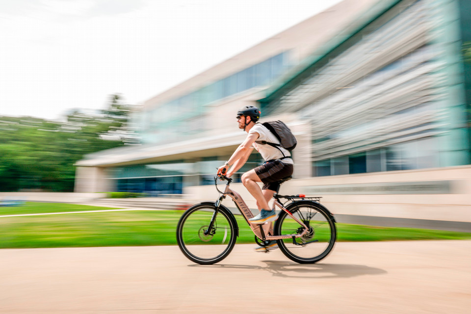bike rider passes the shapiro campus center