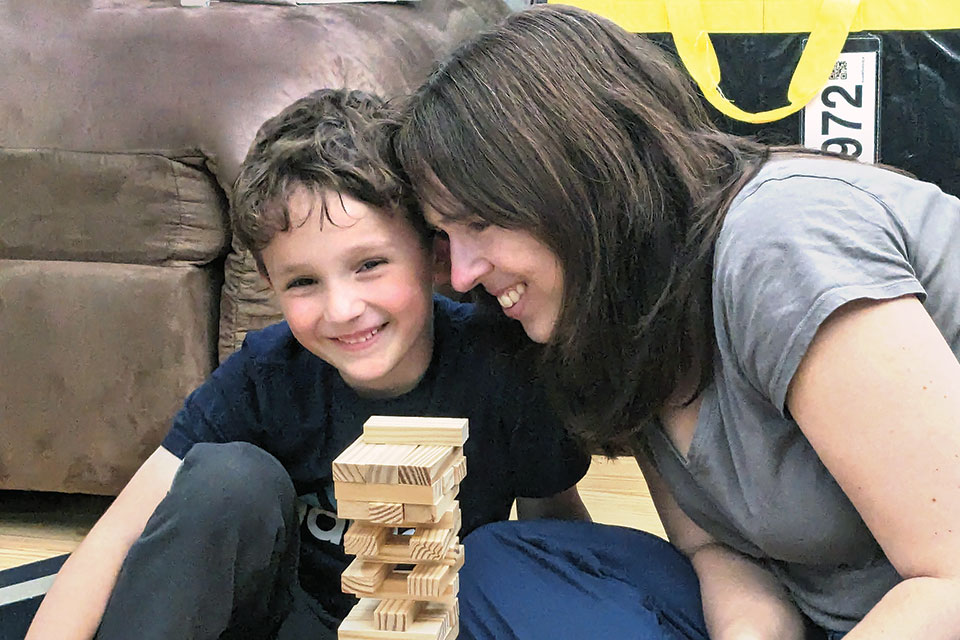 Meredith Bodgas and her son play Jenga.