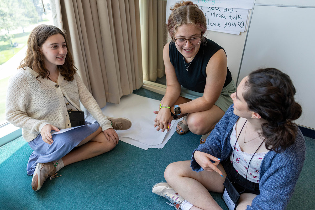 Two Genesis program students speak with their instructor.