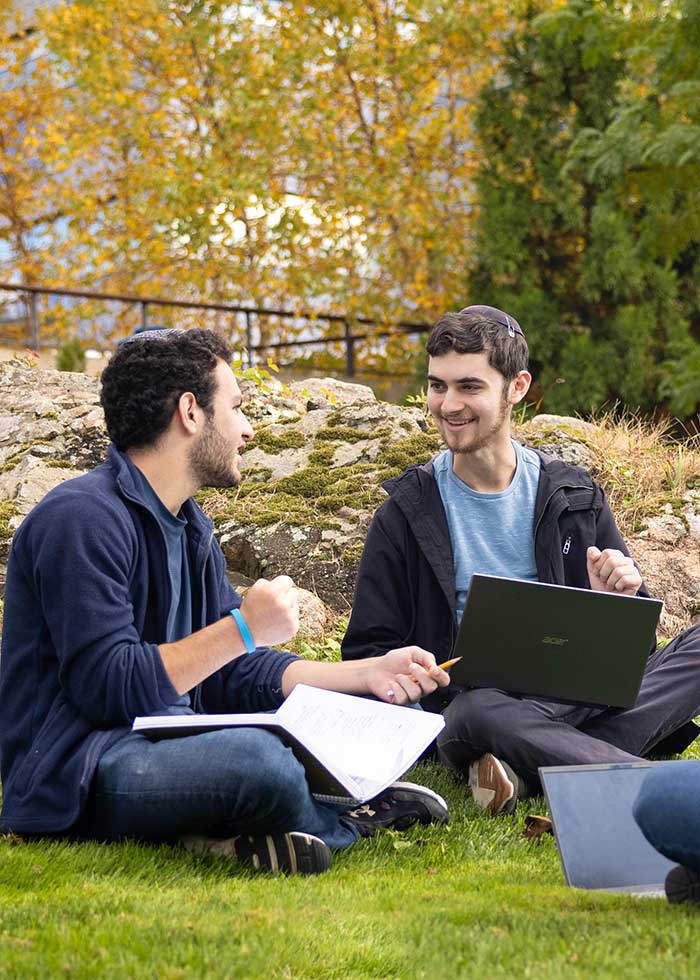 A group of students walk outside on the Brandeis campus.