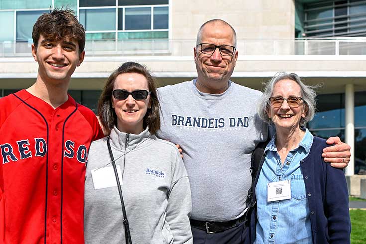 Parents hug their student while posing for a photo during Family Weekend.