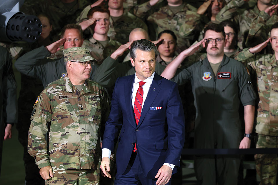 Defense secretary Pete Hegseth walking in front of a group of soldiers.