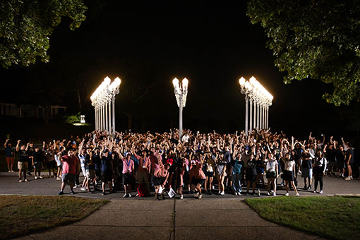 First year students standing in front of the Light of Reason at 'Light the Night' during Orientation