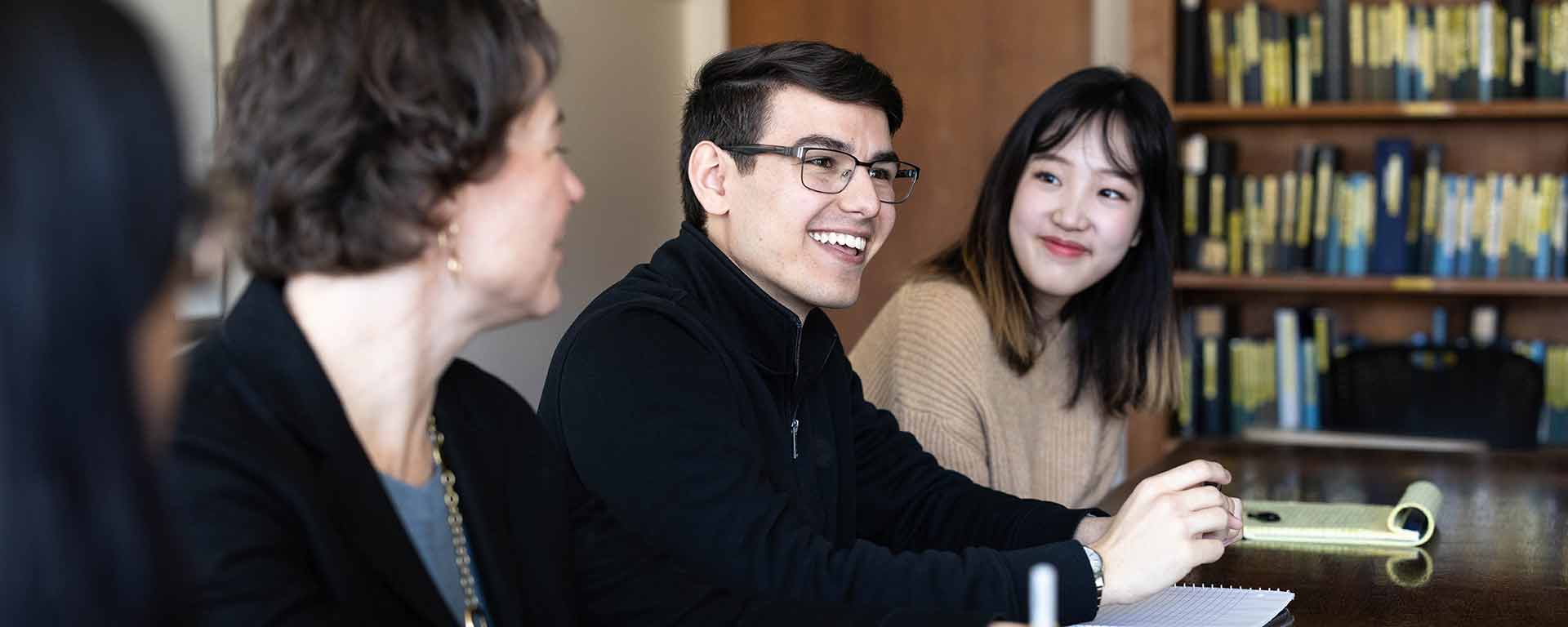 Students and faculty talking around a table