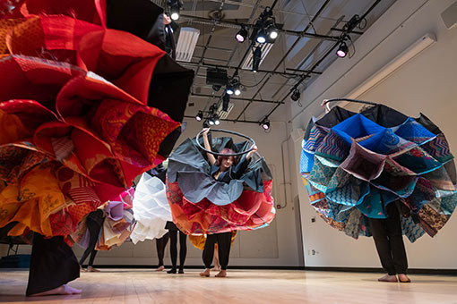 Students perform a dance while wearing homemade sensory augmentation devices as part of a project that explores how vibrational cues affect movement during dance.