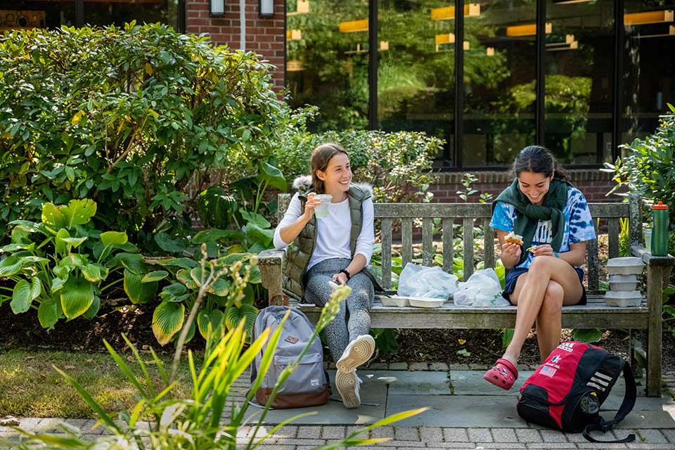 Students sit on a bench outside