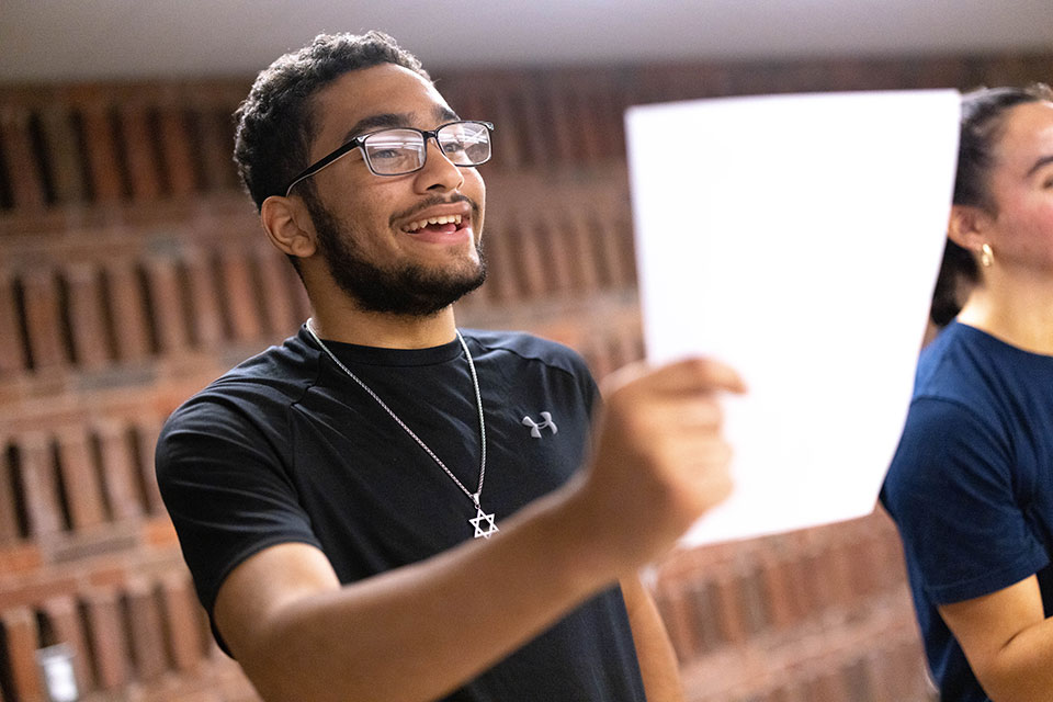 Tyler reads off of a sheet of paper in a politics class