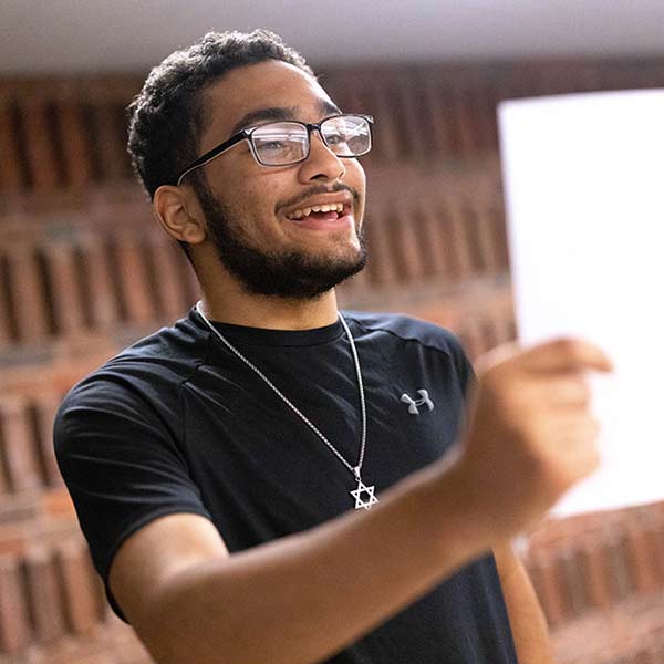 Tyler reads off of a sheet of paper in a politics class.