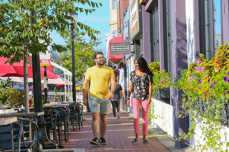 Two people walk down Moody Street in Waltham.